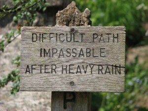 sign post along the path reads "difficult path - impassable after heavy rain"
